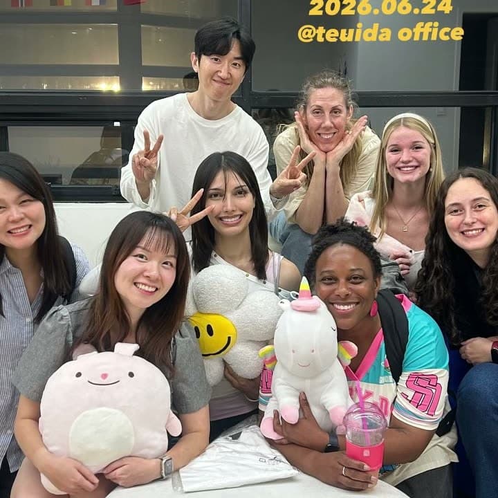 KND members around a table holding plush toys at a June 2026 gathering